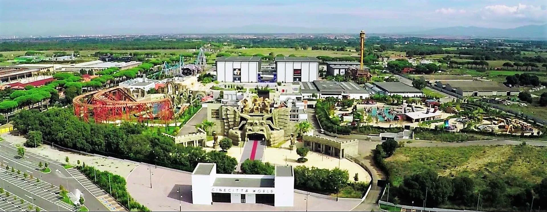Daytime aerial view of Cinecittà World: the Roma area with its classical buildings visible in the foreground, red Altair coaster and soundstages visible