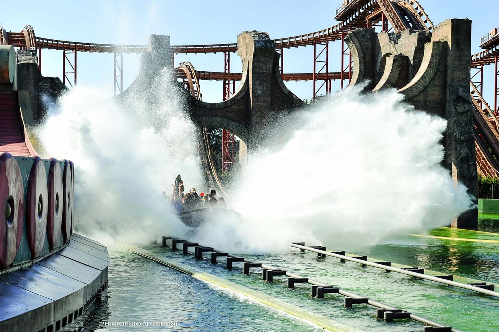 Aktium in action: the great drop of the Super Splash water coaster with the 16-passenger boat producing a white water wave, ancient-Rome scenography on the sides