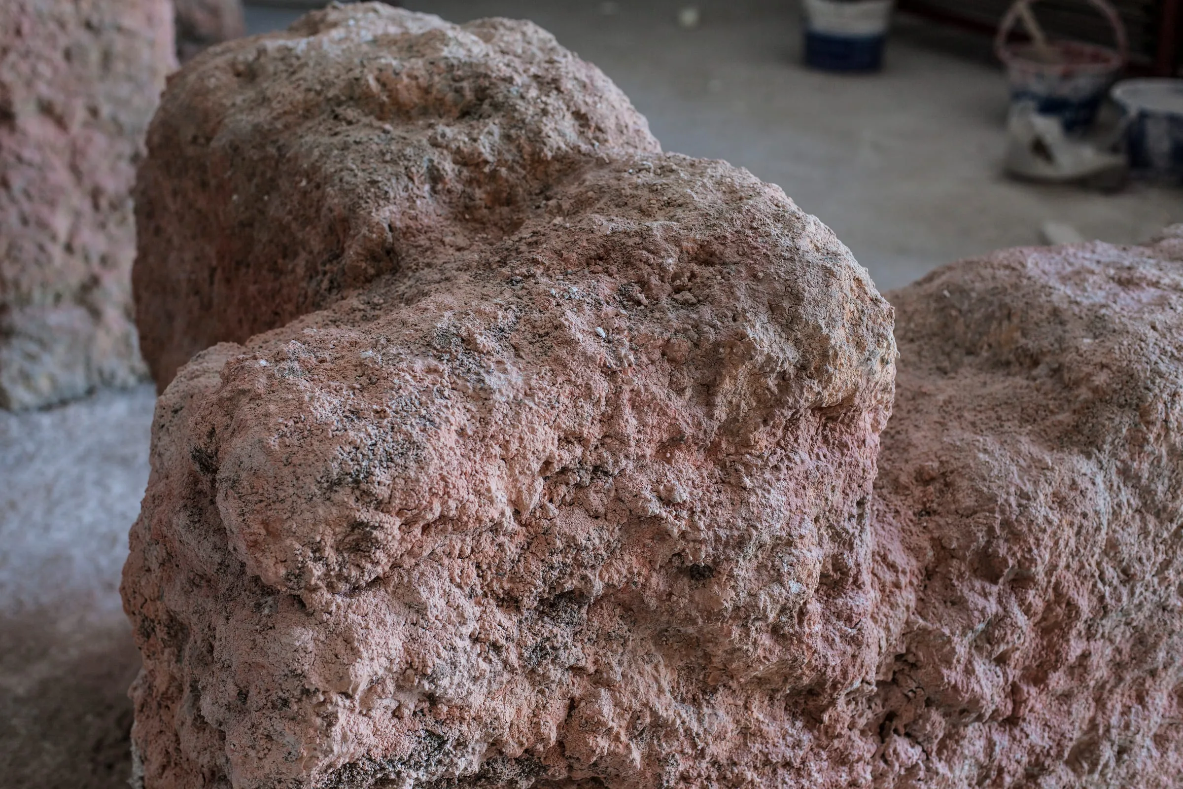 Dettaglio ravvicinato della muratura della Sala: superficie color sabbia con crepe verticali, friabilità simulata, mattoni crudi appena distinguibili nel grezzo