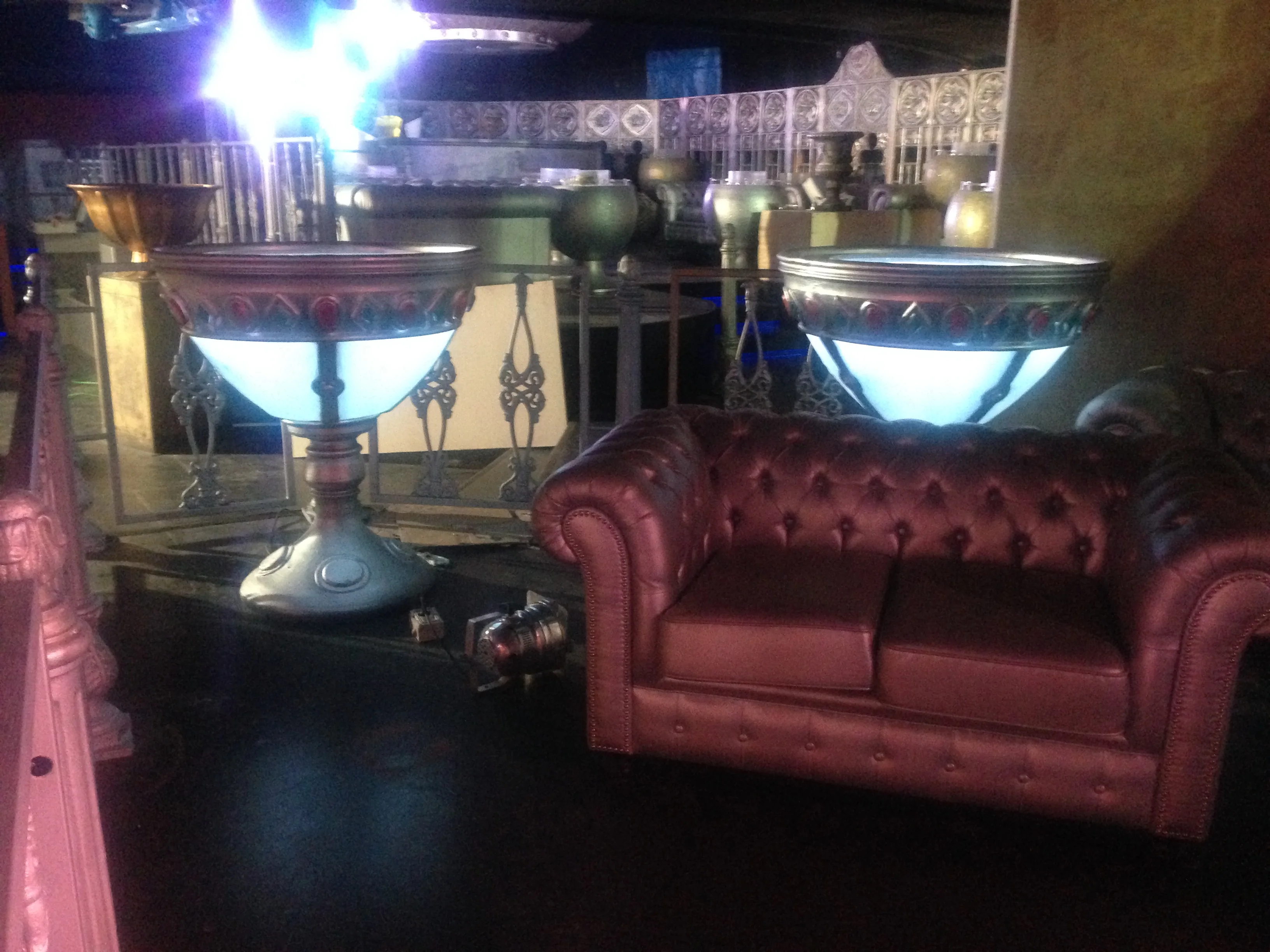 Overview of the dance-floor area of Art Café: dance floor with stage lights, one of the scenographic goblets in the background, metallic decorations of the venue, evening club atmosphere