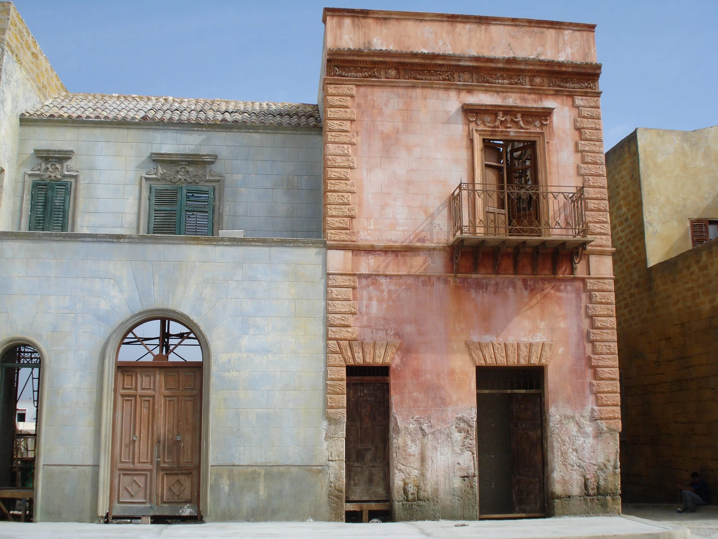 View of the Baarìa set under construction in Tunis: raw facades, active scaffolding, palms of the Ben Arous suburbs in the background