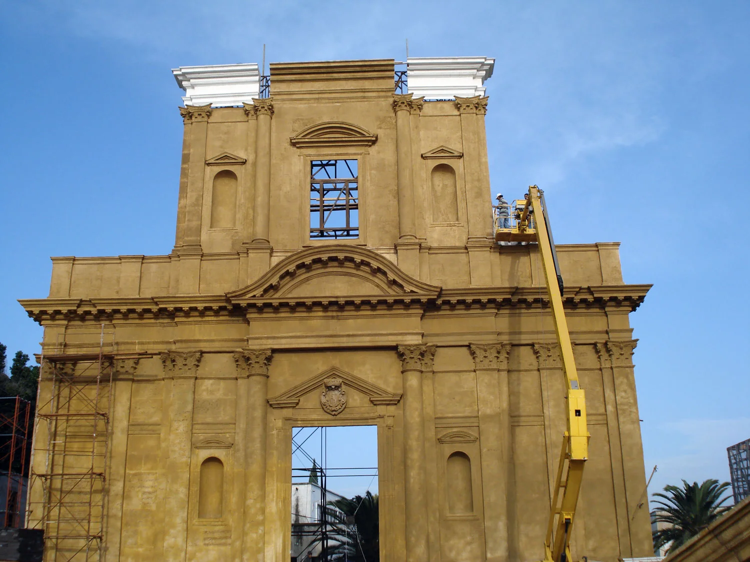 Sicilian Baroque monumental gateway in mustard yellow, rebuilt to scale 1:1 with a double order of columns and friezes