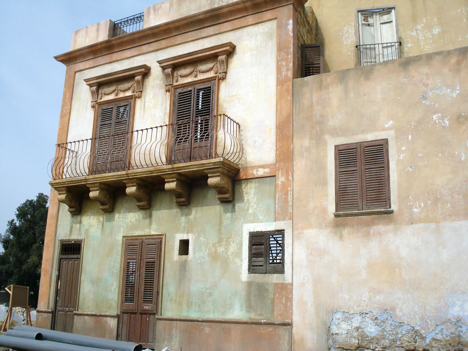 A street of Bagheria with the set completed, before the extras: painted signs, shopfronts, shutters, urban details of the Thirties