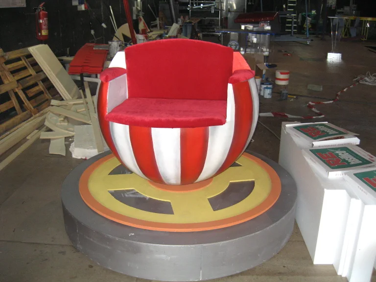 Red scenic ball-armchair with white stripes on a golden crown base