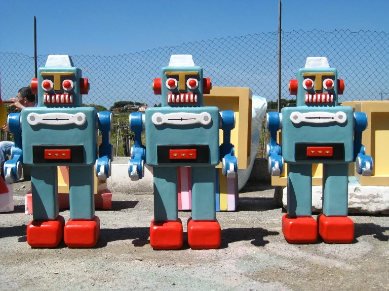 Three identical retro robots sculpted in fibreglass