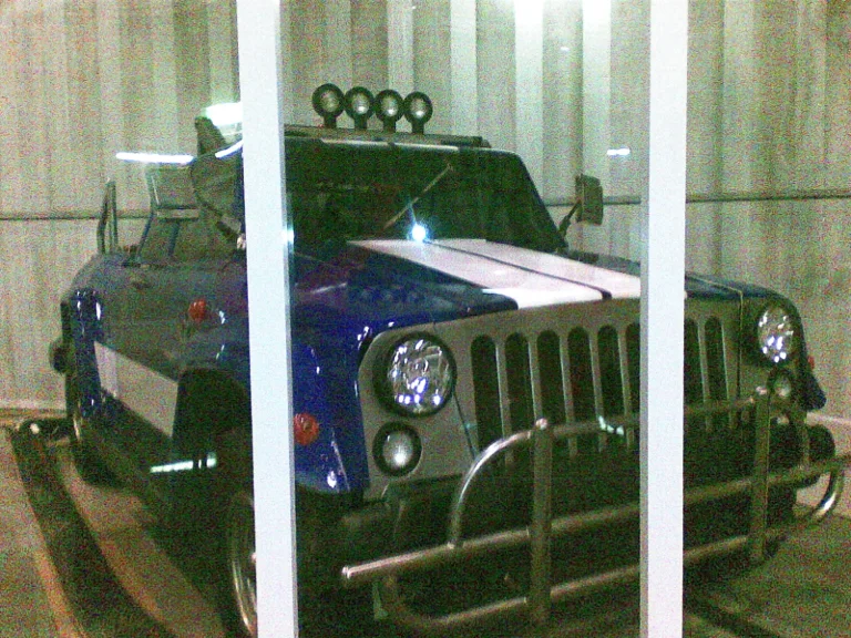 The closed blue car from the front: stylized six-wheel SUV