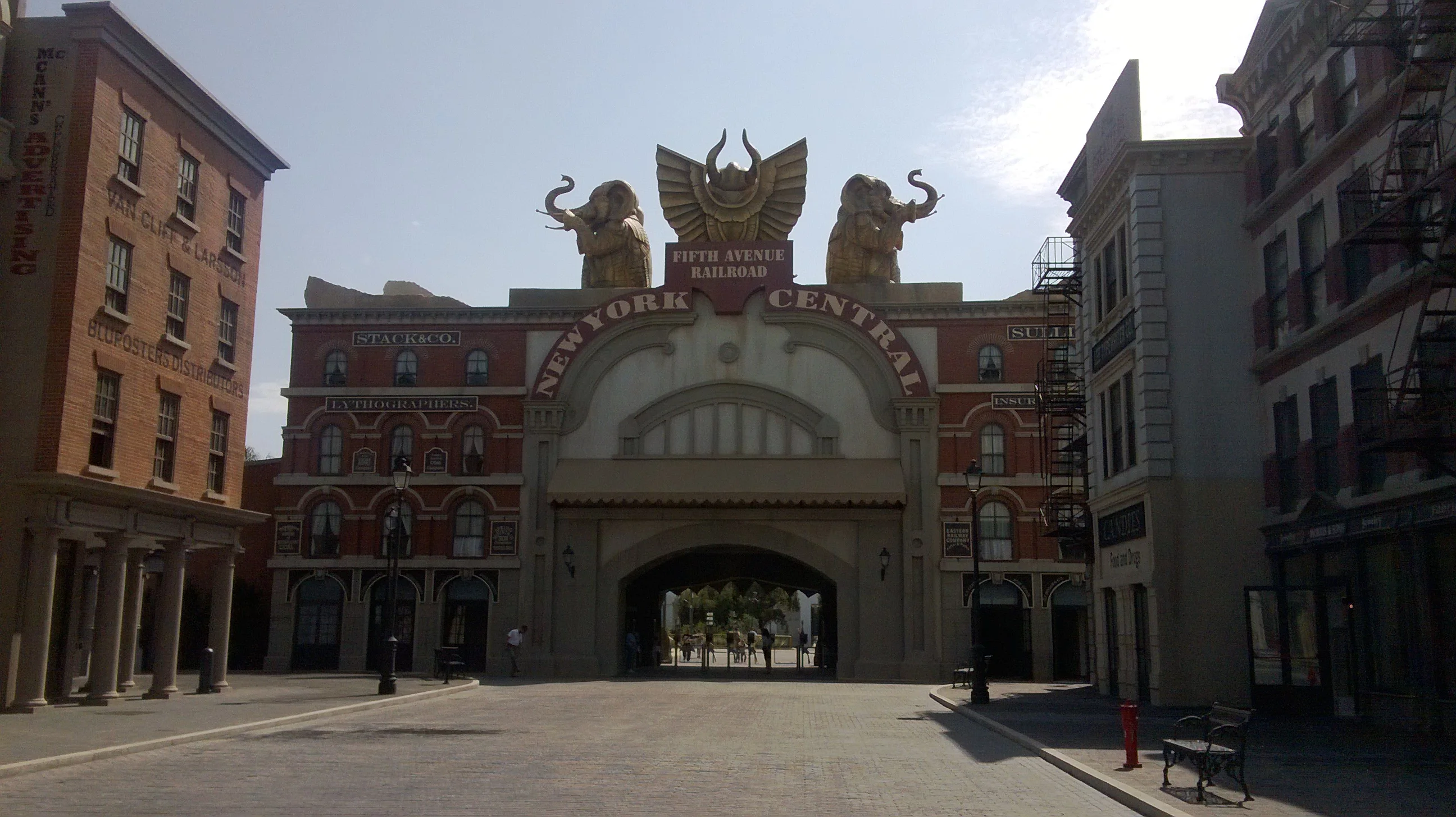 Fifth Avenue Railroad-style gate at Cinecittà Street: two golden elephants on the sides, winged red dragons, large central round arch, 'NEW YORK CENTRAL' inscription above