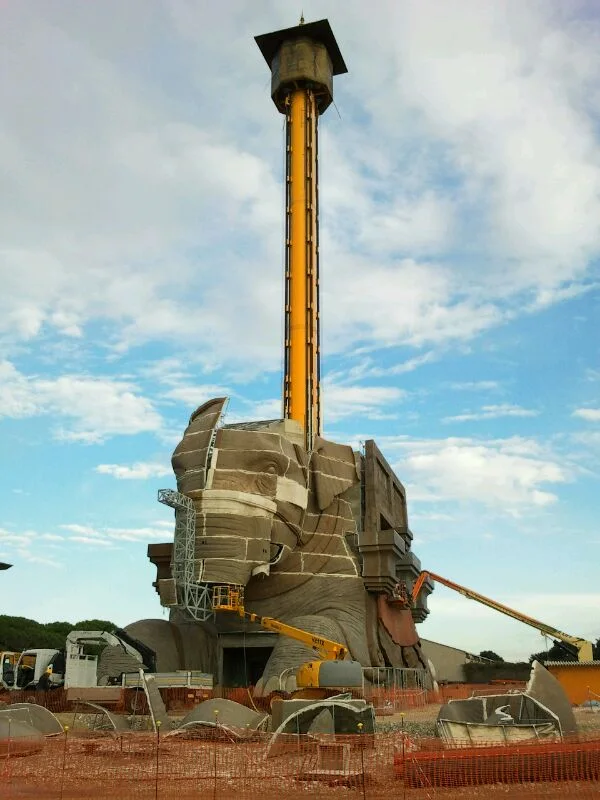 The elephant under construction: sculpted body, the yellow tower of the 60-metre Intamin drop tower with the cabin on top sticks out of its back