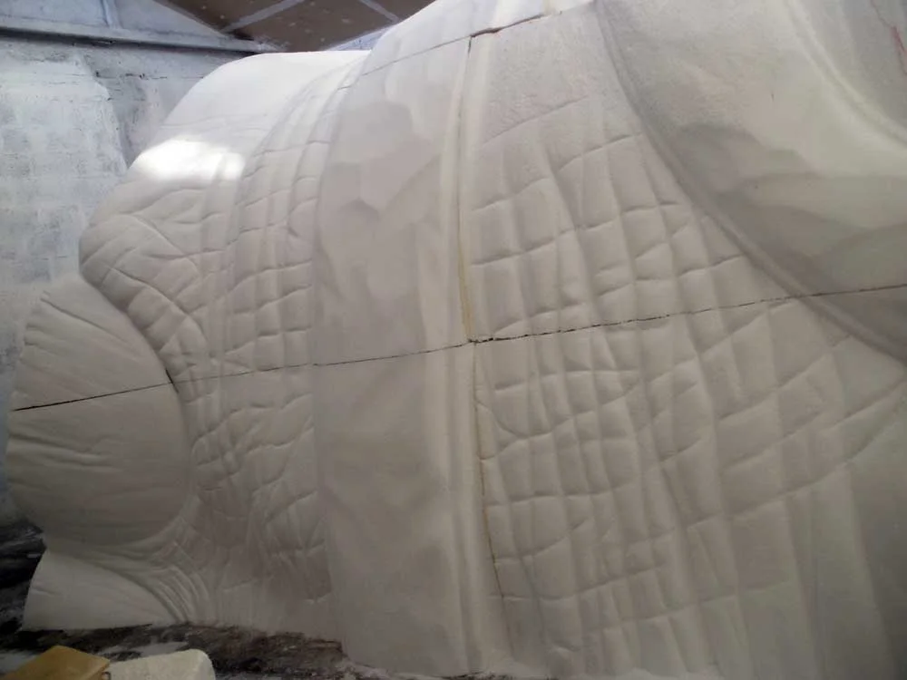 Another piece of the elephant: front view of a block sculpted in white polystyrene with skin folds, curved muscular sections