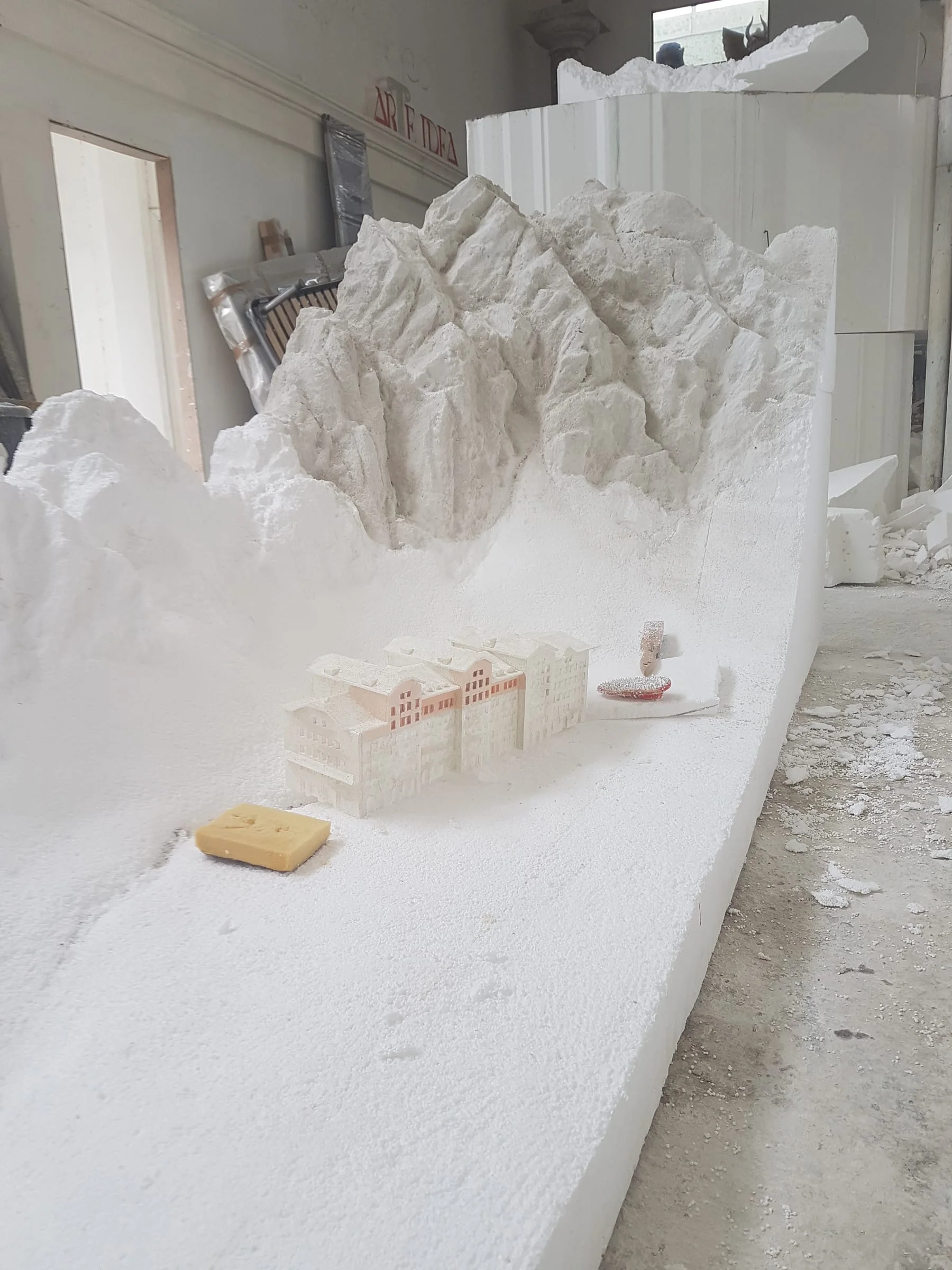 Early phase of the model: the mountainous reliefs just sculpted in white expanded polystyrene, first coloured houses laid