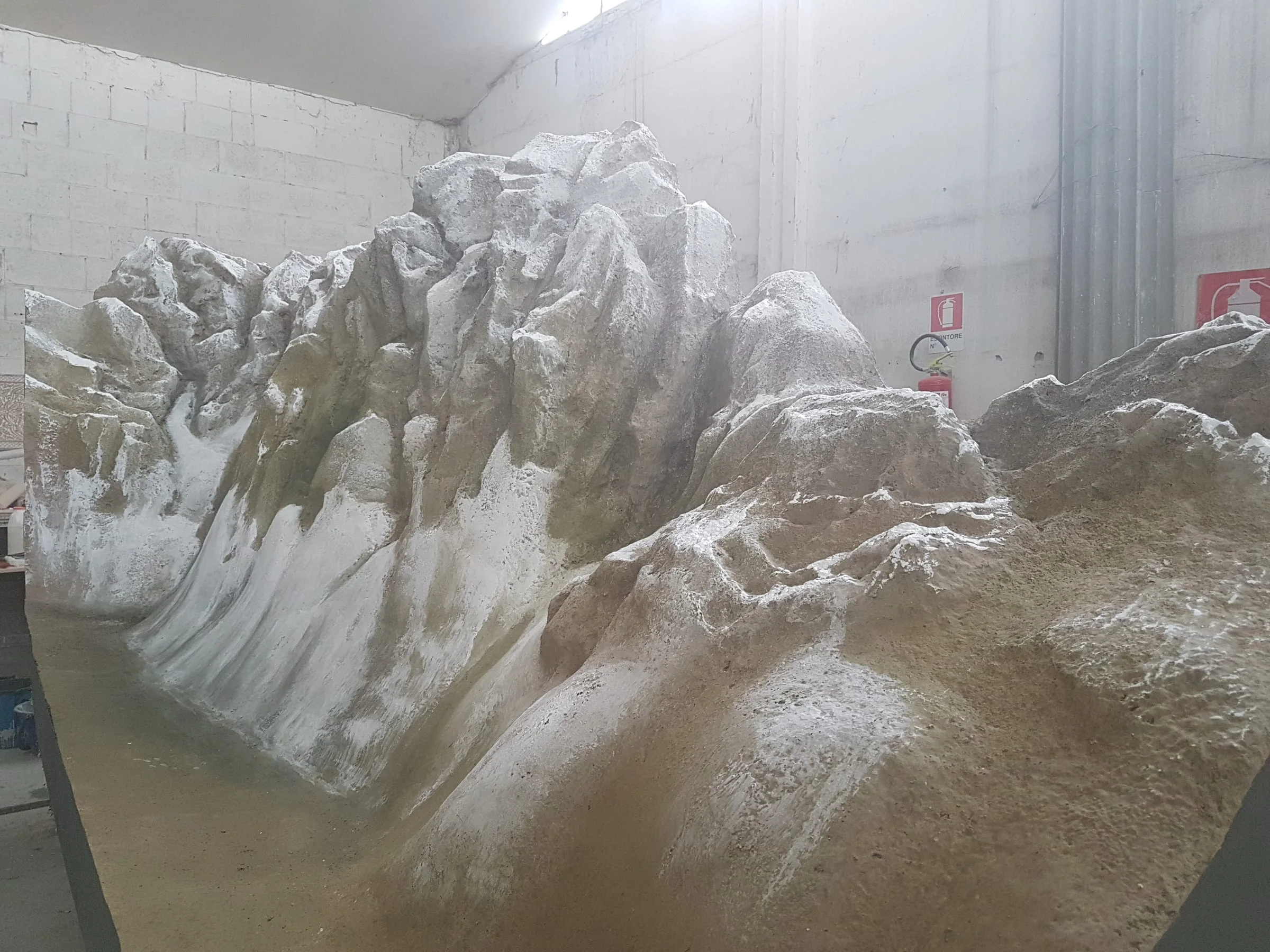 Only the mountains of the model: rocky relief sculpted and patinated with snow white, inside the workshop