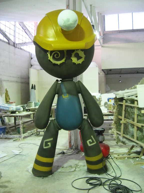 View of the workshop site during the fabrication of a scenographic piece for Little Big Town: polystyrene carving, painting equipment, warehouse floor