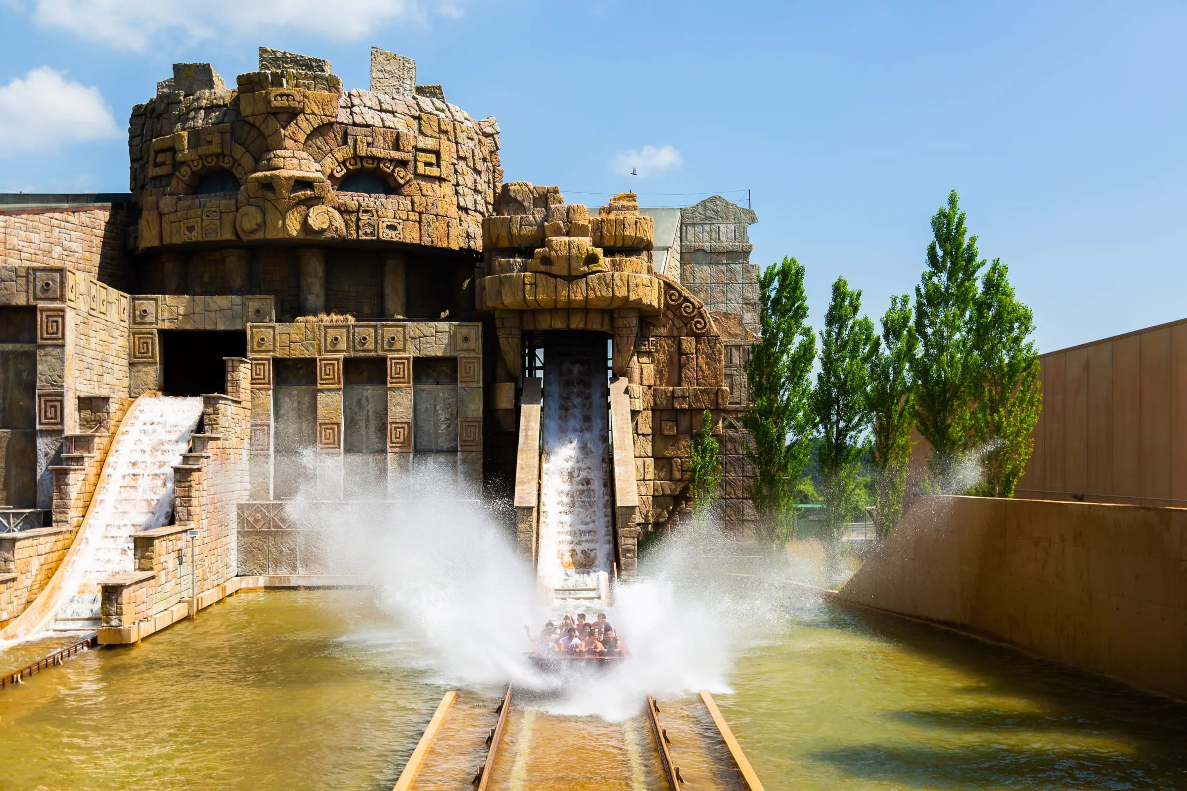 The Yucatan attraction installed at Rainbow MagicLand in Valmontone: view of the fibreglass Mayan temple delivered by Creation Art as the signature piece of the Spill Water, stepped pyramid façade with central staircase, tropical vegetation around, the ride's water course in the foreground