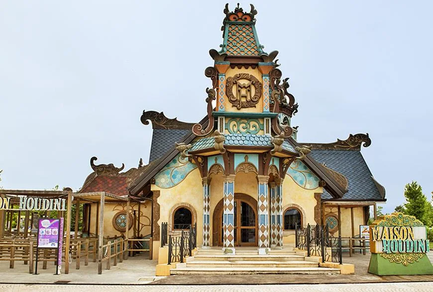 Dettaglio decorativo ravvicinato della facciata Maison Houdini: mascherone, cornici, motivi a rilievo dell'iconografia Belle Époque dell'illusionista