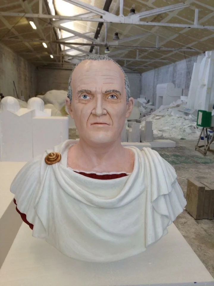Detail of a full-round portrait sculpted in the Creation Art workshops: female polychrome figure, wavy hair, front view of the face