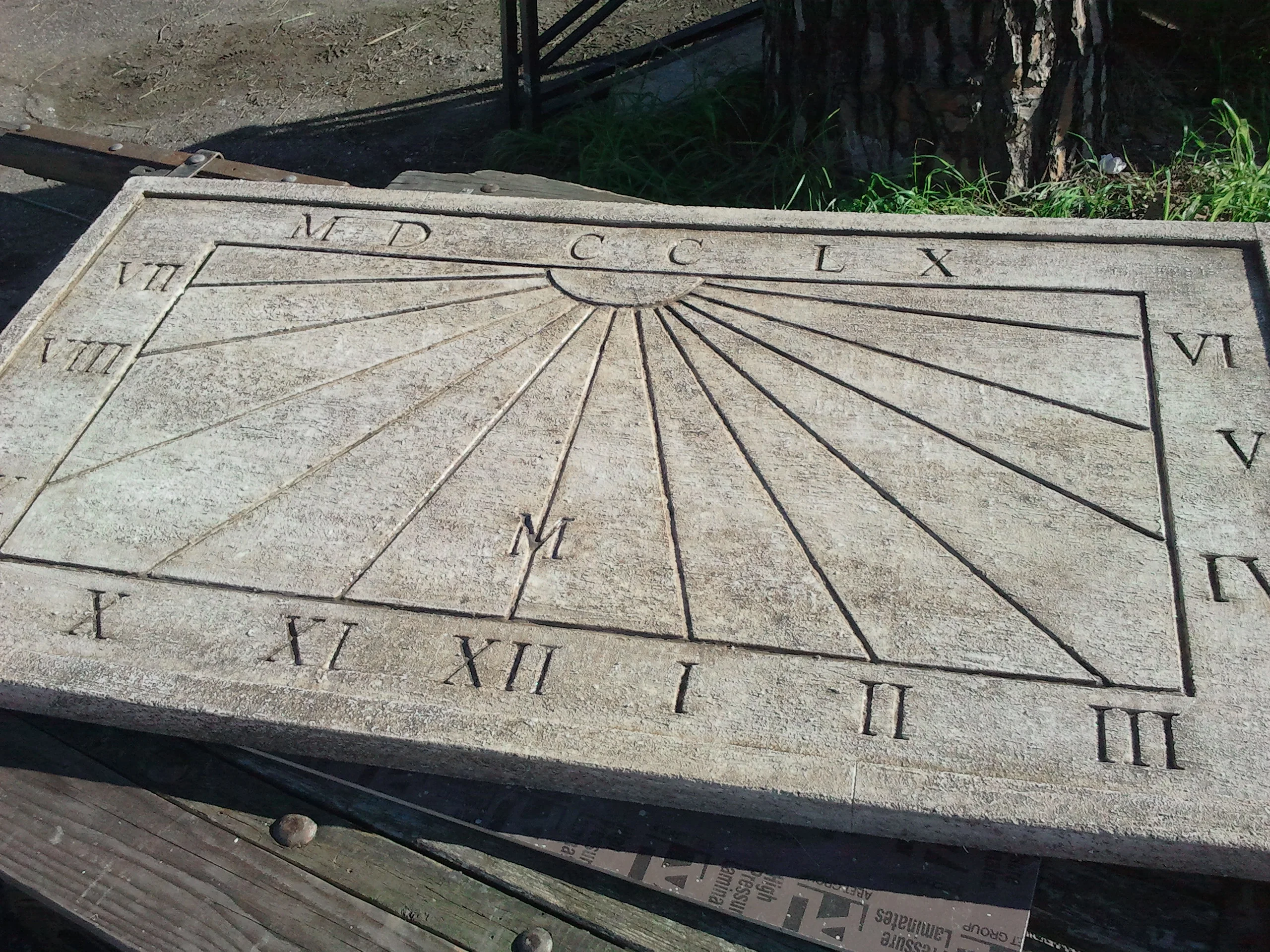 Another view of the sundial carved for Peroni, from a different angle, detail of the sand-coloured patina and the Roman numerals