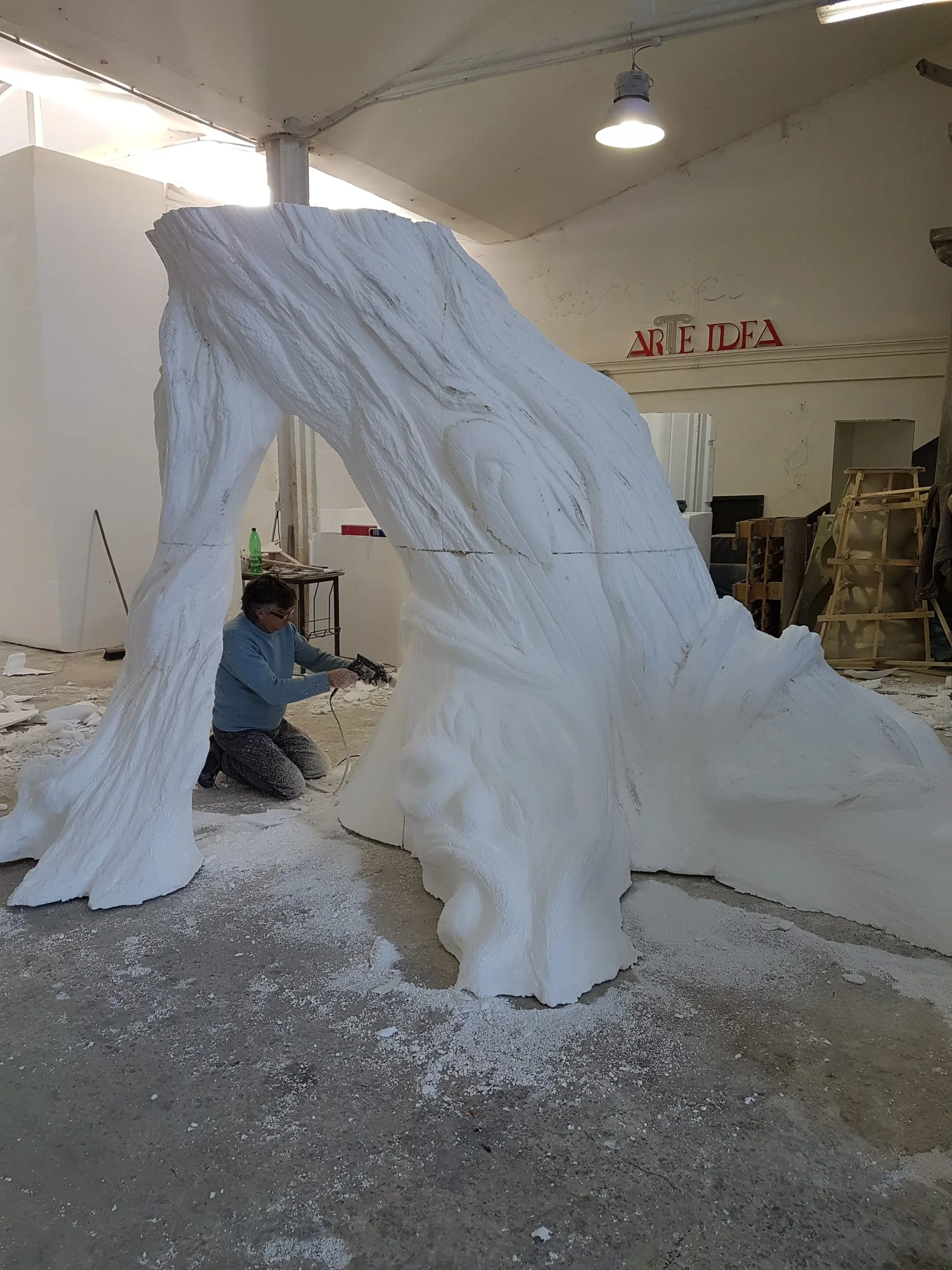 A monumental tree trunk in white expanded polystyrene, already sculpted at life size, standing in our Creation Art workshop